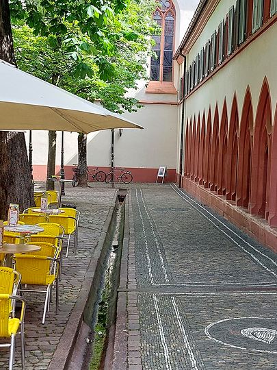 Freiburg, arcades and café tables